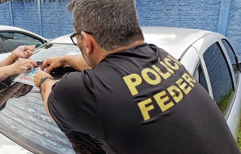 Policial federal remove propaganda considerada irregular em um veículo estacionado perto do colégio Costa e Silva. Foto: Marcos Labanca/H2FOZ